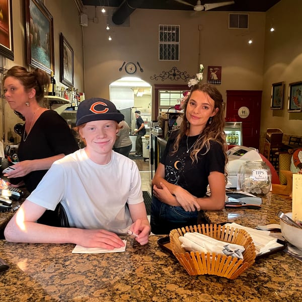 Three Italian To Go / Bit Of Italy employees, two at the counter and one in the kitchen.